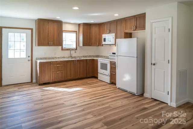 a kitchen with stainless steel appliances granite countertop a refrigerator sink and cabinets