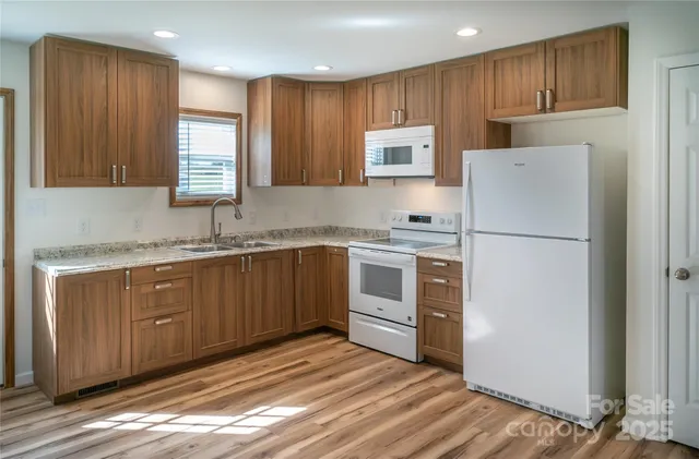 a kitchen with white cabinets and white appliances