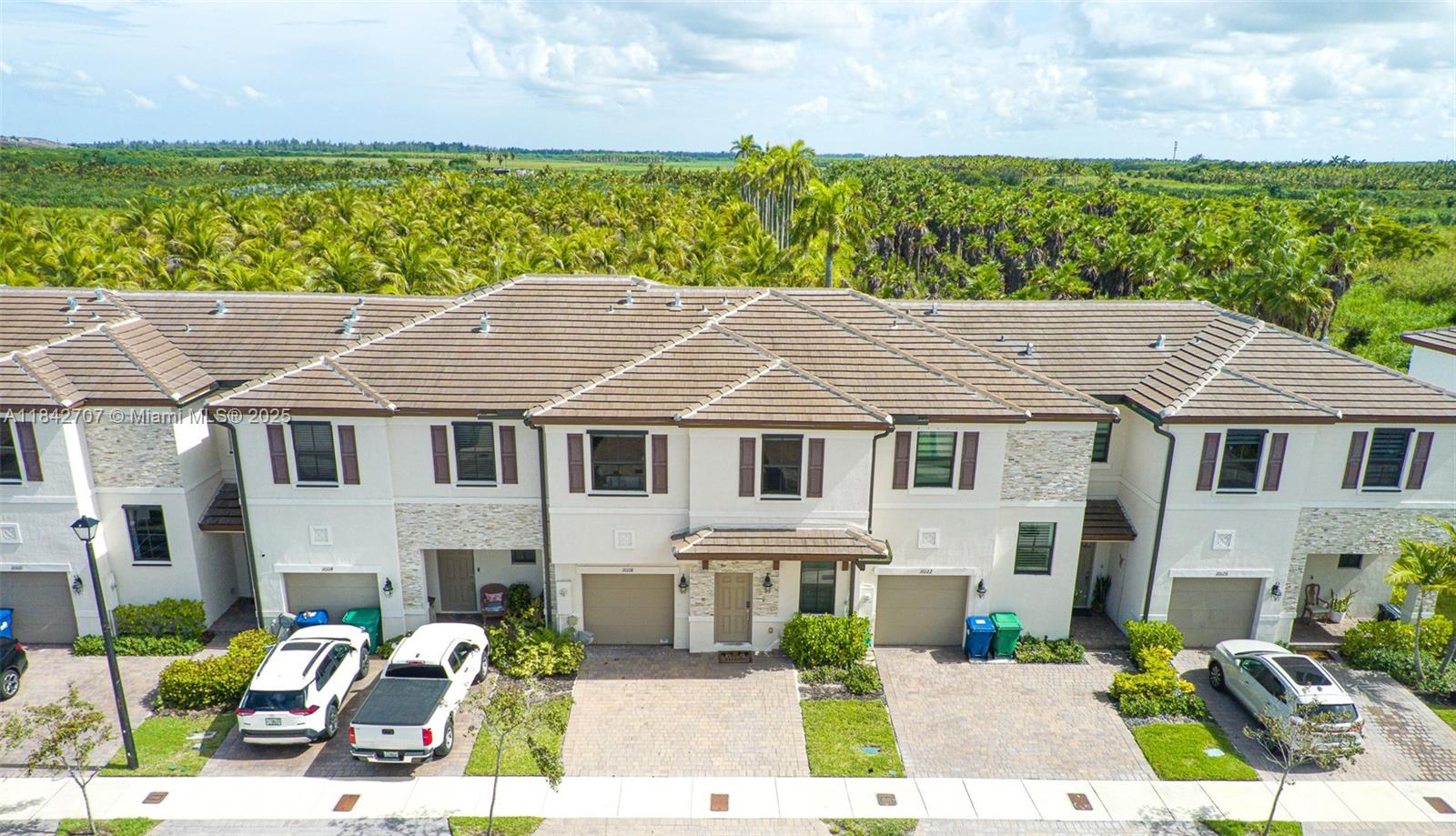 10118 Southwest 231st Lane Miami, FL 33190 - Photo 1 of 19 a aerial view of a white house with a yard plants and large tree