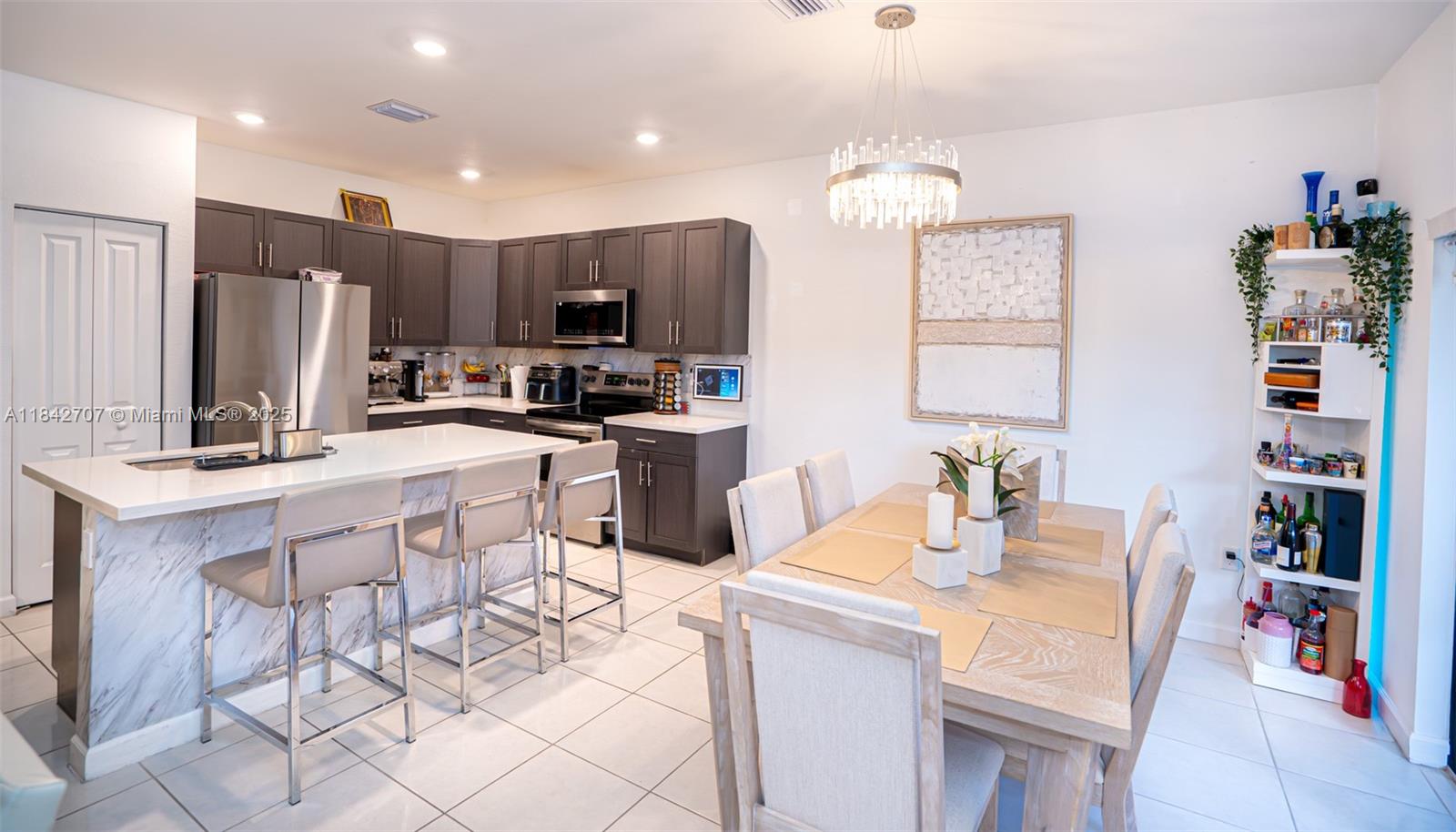 10118 Southwest 231st Lane Miami, FL 33190 - Photo 15 of 19 a kitchen with stainless steel appliances kitchen island granite countertop a sink cabinets and microwave
