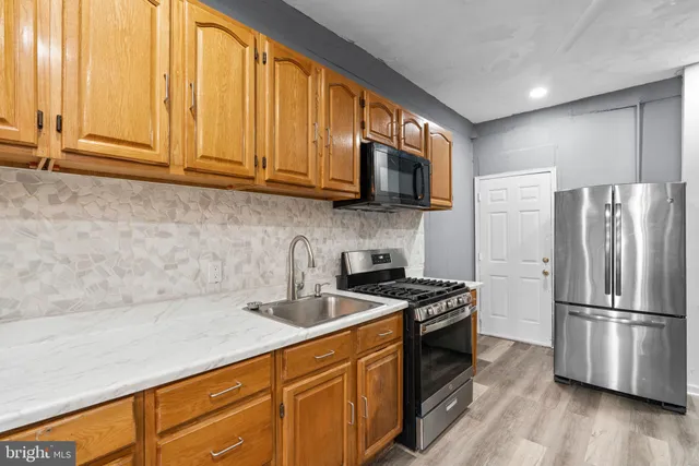 a kitchen with stainless steel appliances a stove sink and microwave