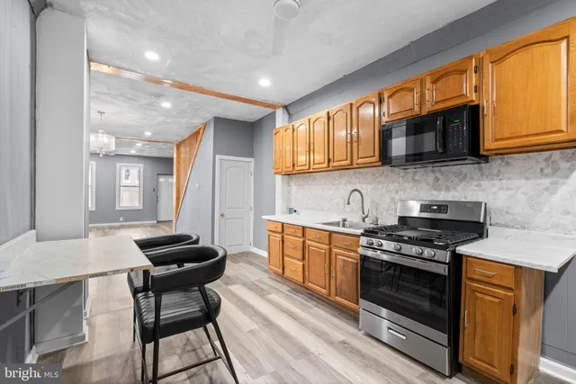 a kitchen with stainless steel appliances kitchen island granite countertop a stove and a sink