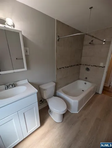 a bathroom with a sink toilet vanity and tub