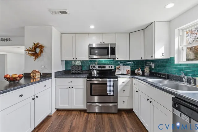 a kitchen with stainless steel appliances granite countertop a sink and cabinets