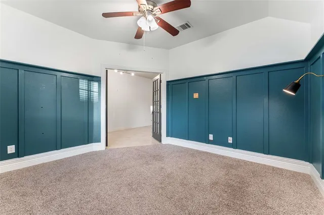 en empty room with closet and a chandelier fan