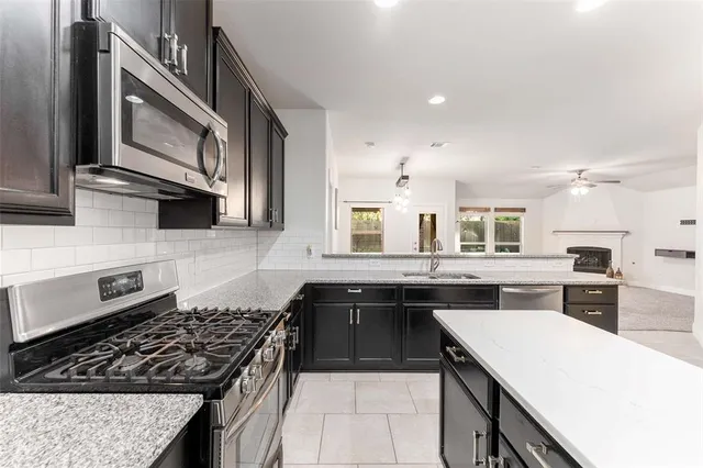 a kitchen with a stove sink and cabinets