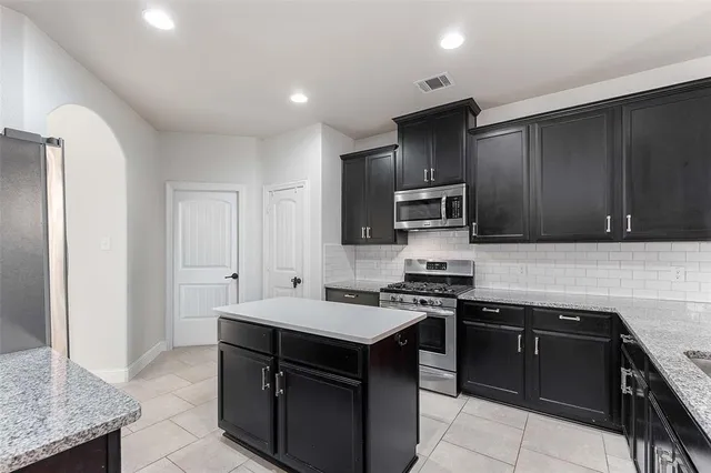 a kitchen with stainless steel appliances granite countertop a stove and a sink