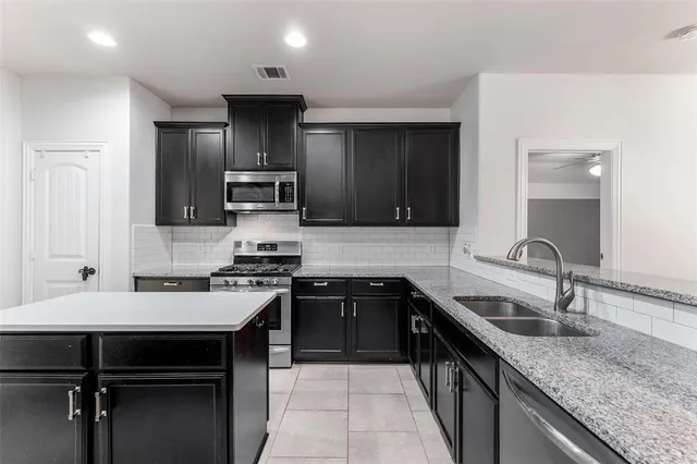 a kitchen with a sink stove and cabinets