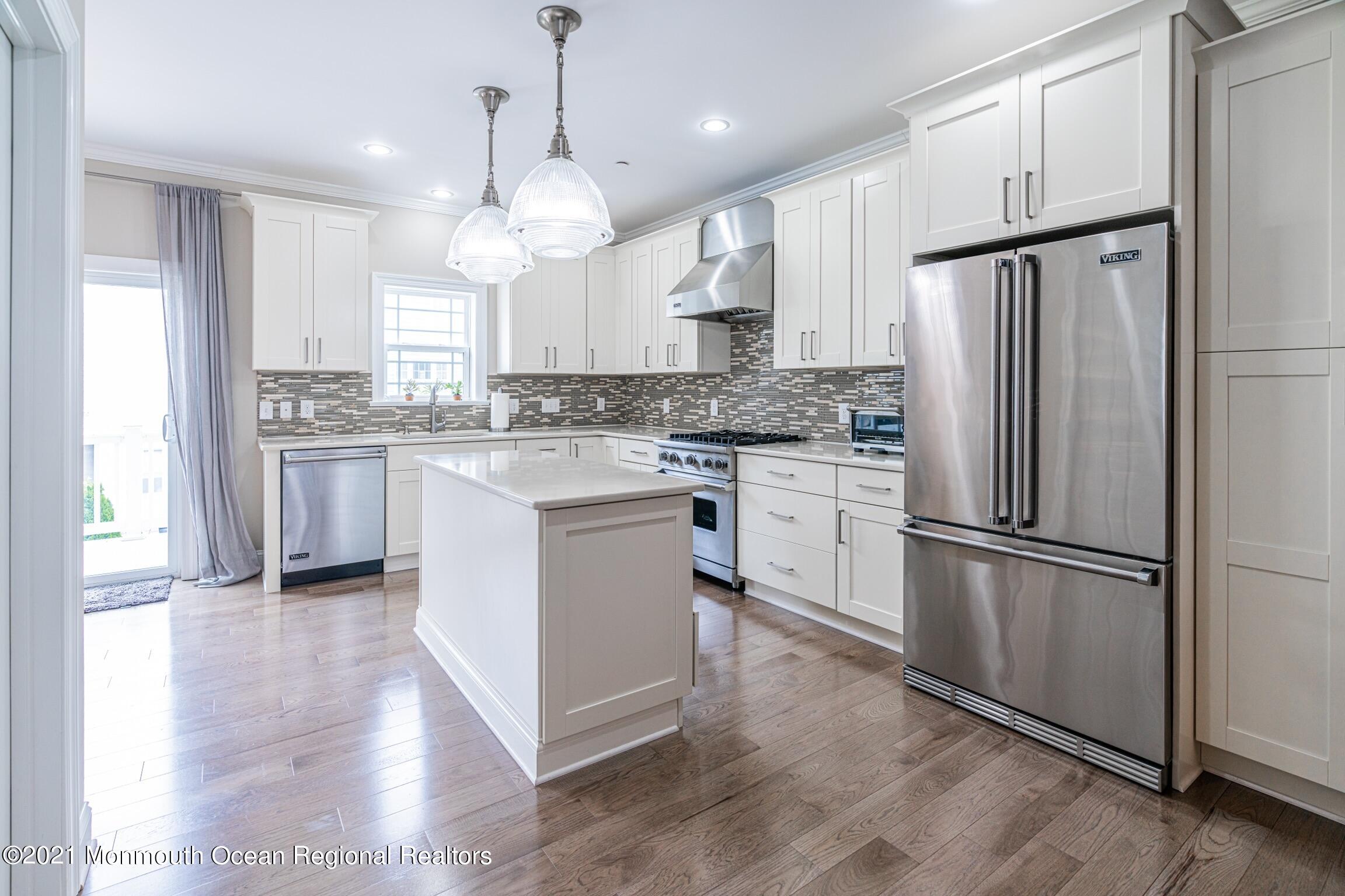 a kitchen with stainless steel appliances granite countertop a refrigerator a stove a sink and a refrigerator