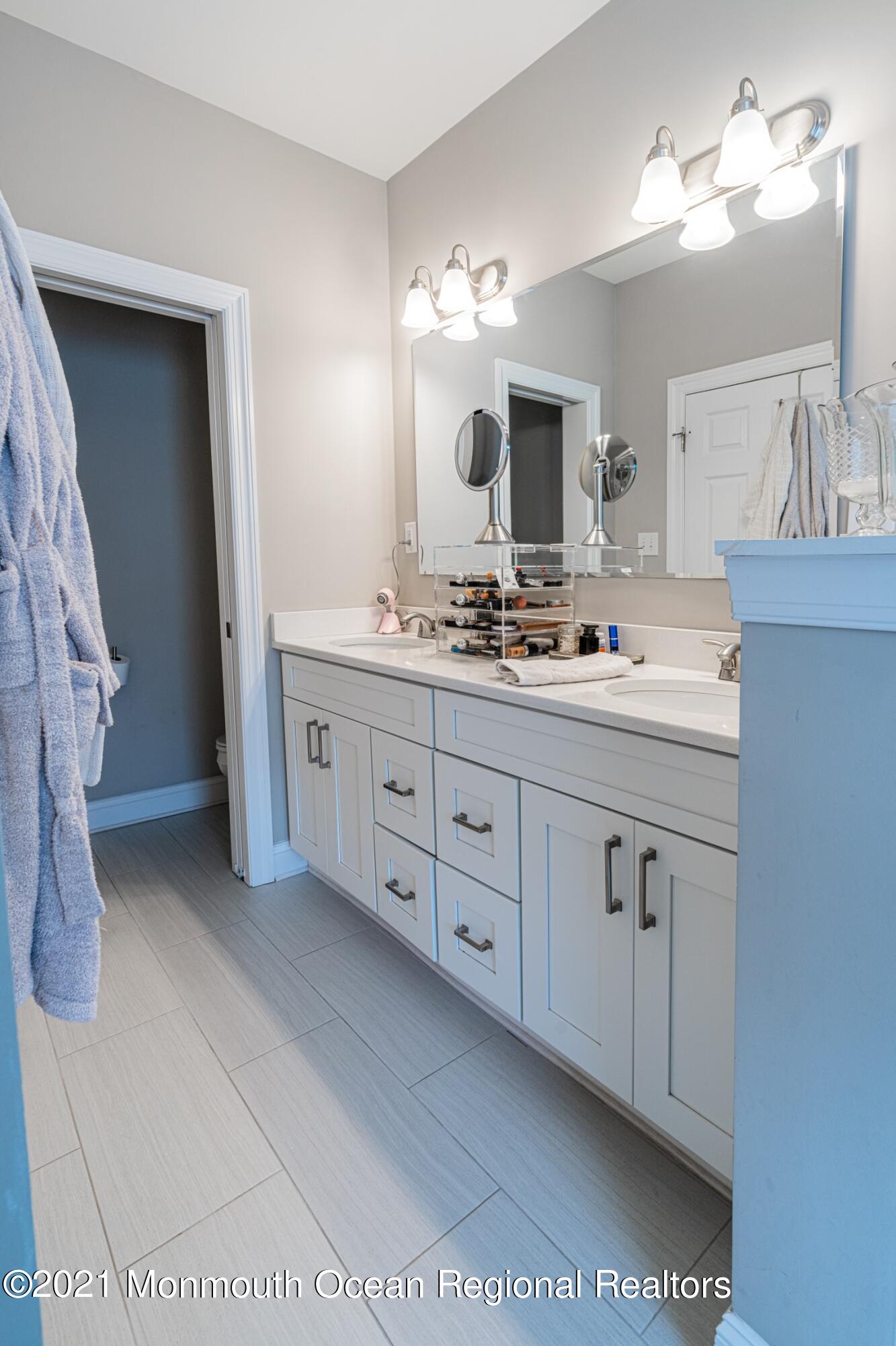 67 Ocean Terrace Long Branch, NJ 07740 - Photo 14 of 20 a spacious bathroom with a double vanity sink and a mirror