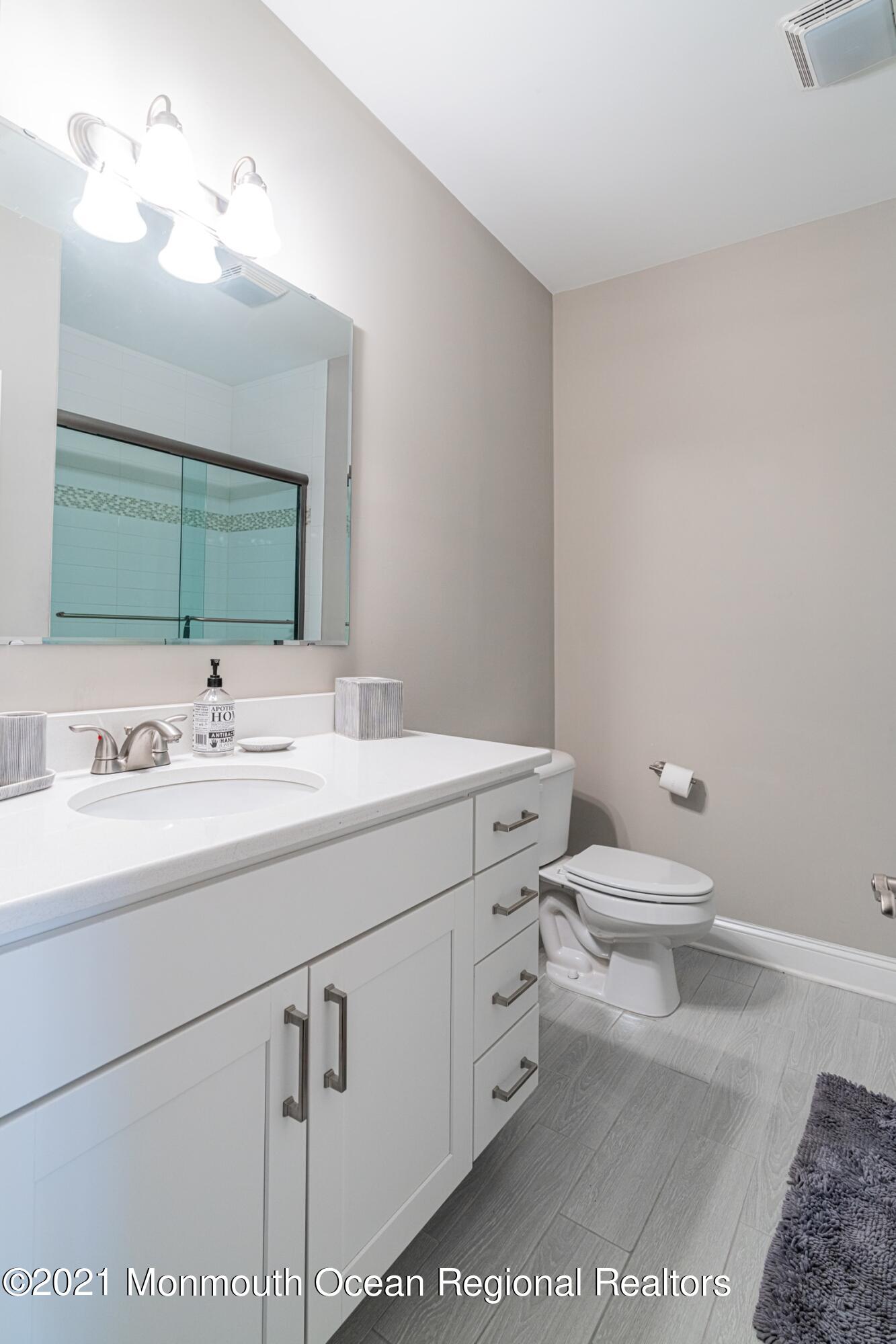 67 Ocean Terrace Long Branch, NJ 07740 - Photo 18 of 20 a bathroom with a toilet sink and mirror