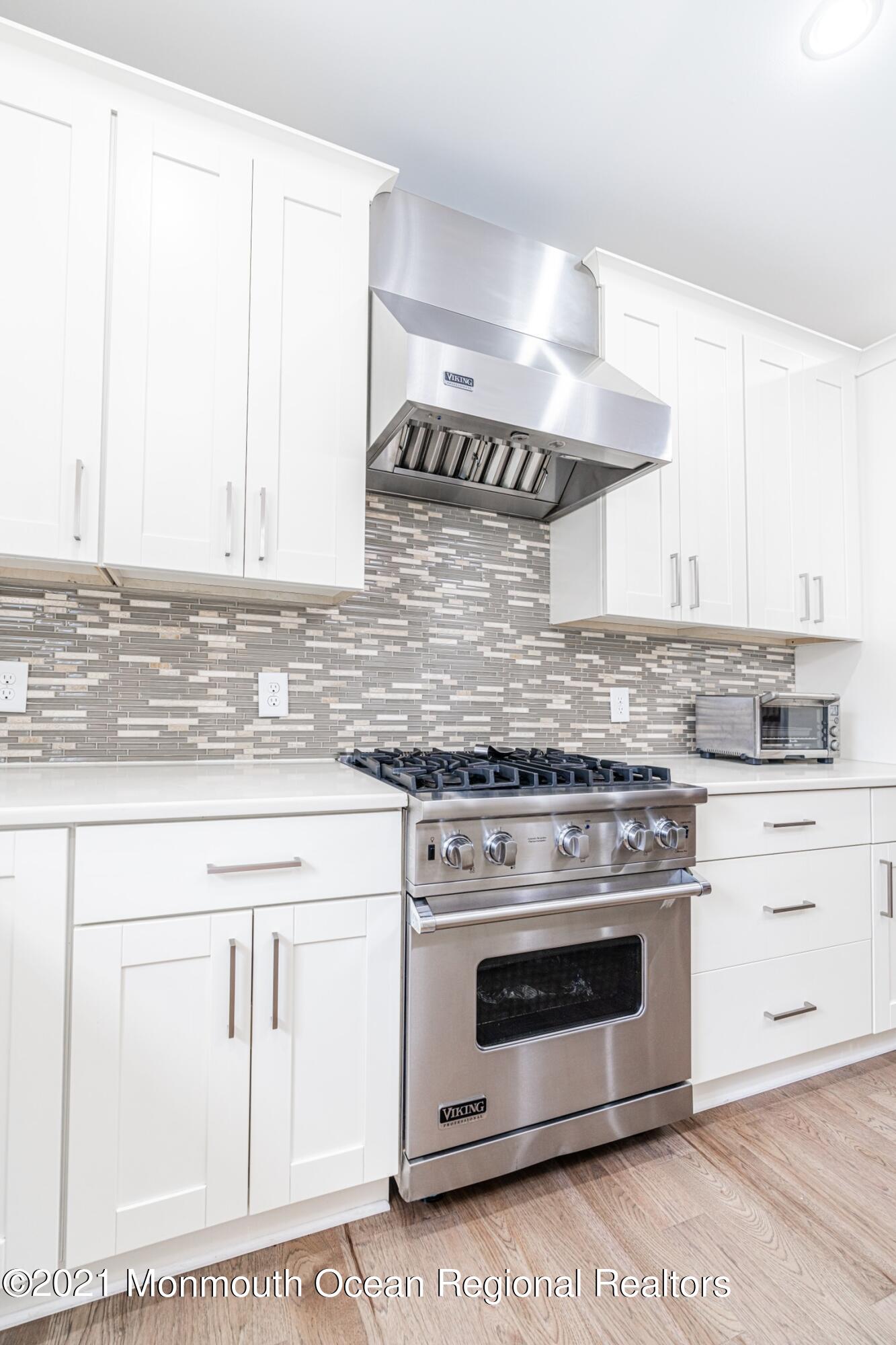 67 Ocean Terrace Long Branch, NJ 07740 - Photo 3 of 20 a kitchen with granite countertop white cabinets and white stainless steel appliances