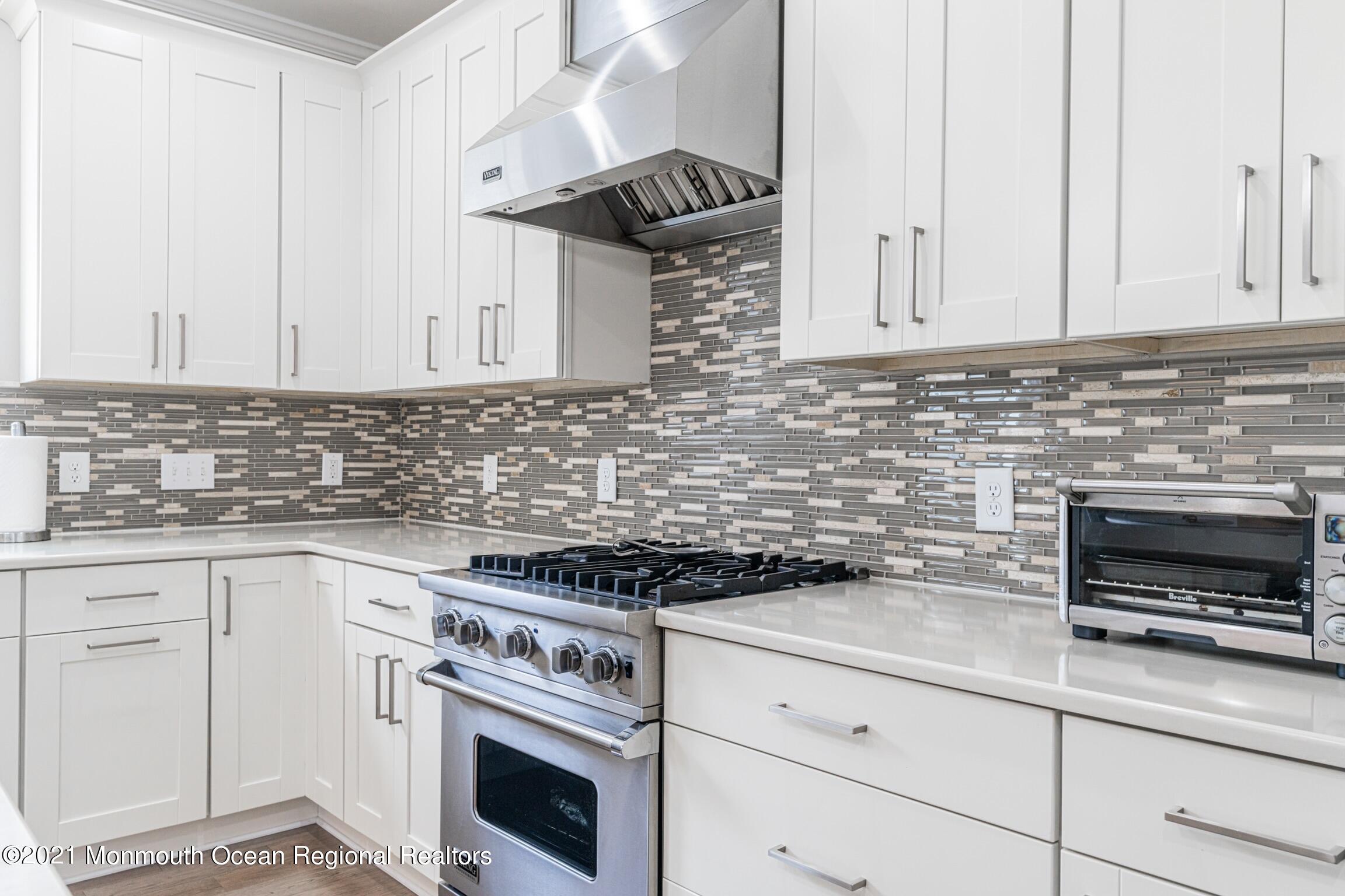 67 Ocean Terrace Long Branch, NJ 07740 - Photo 4 of 20 a kitchen with granite countertop white cabinets and white appliances