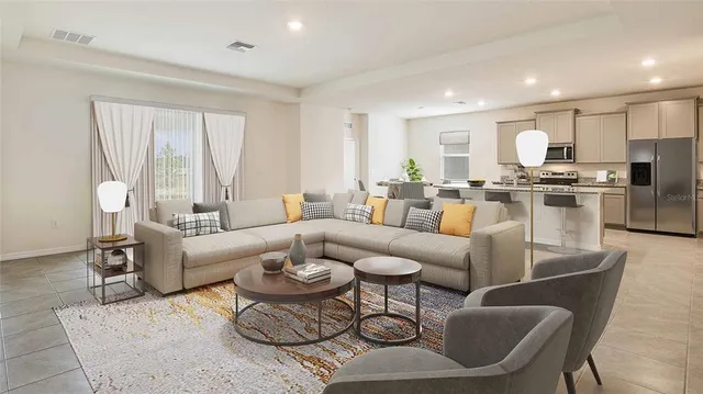 a living room with furniture kitchen view and a large window