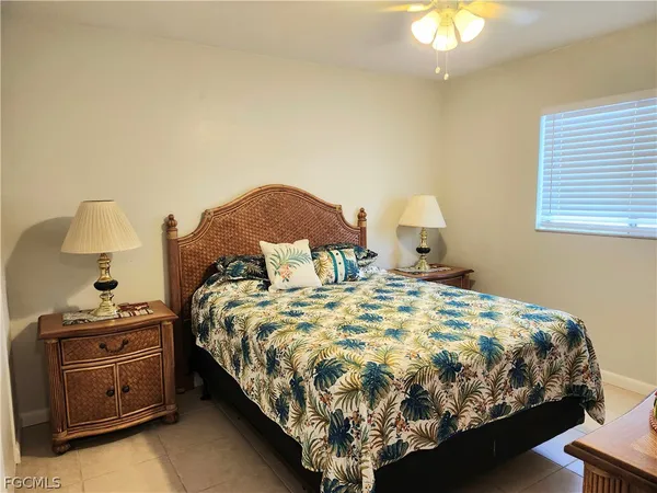 a bed sitting in a bedroom next to a lamp and a chandelier