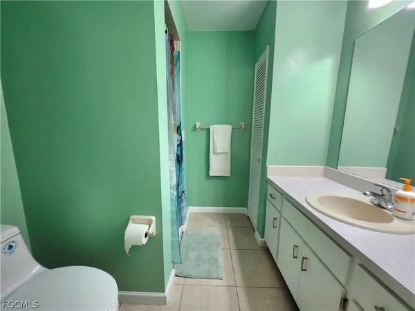 a bathroom with a granite countertop toilet sink and mirror