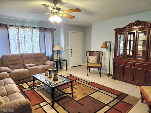 a living room with furniture a ceiling fan and a window
