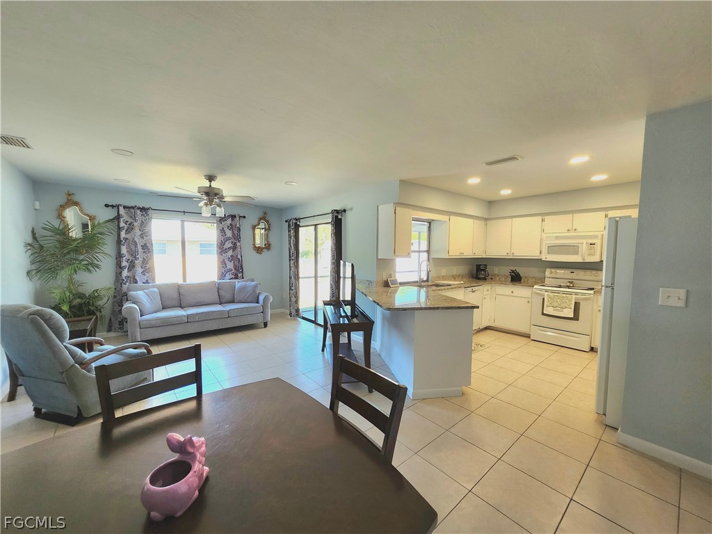 12938 5th Street Fort Myers, FL 33905 - Photo 4 of 25 a living room with furniture and a dining table with kitchen view