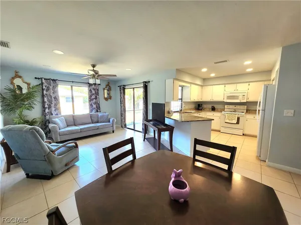 a living room with furniture and a dining table with kitchen view