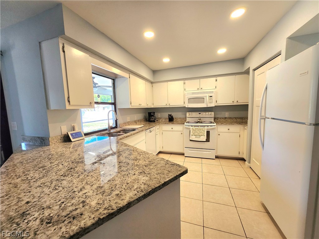12938 5th Street Fort Myers, FL 33905 - Photo 10 of 25 a kitchen with stainless steel appliances granite countertop a stove a sink and a refrigerator