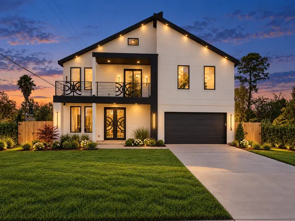a front view of a house with a yard and trees