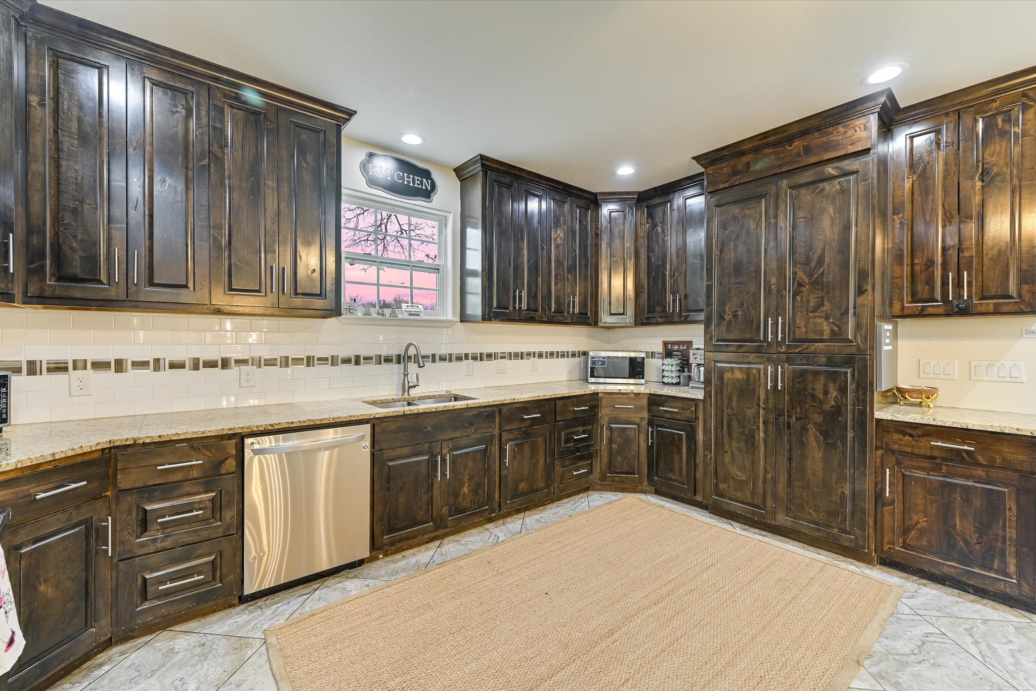 8400 Taylorsville Road Dale, TX 78616 - Photo 8 of 38 Kitchen featuring dark wood finish cabinetry, stainless steel appliances, light stone counters, and tasteful backsplash