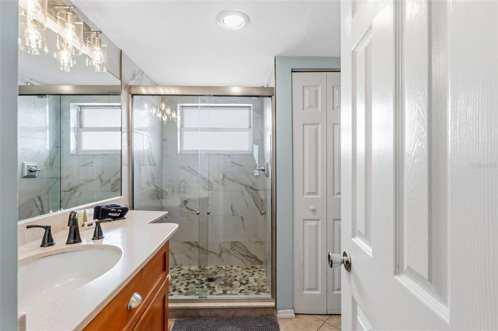 6300 Midnight Pass Road, Unit 708 Sarasota, FL 34242 - Photo 32 of 49 a bathroom with a granite countertop sink a mirror and shower