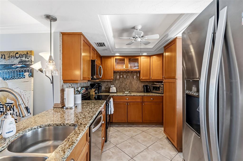 6300 Midnight Pass Road, Unit 708 Sarasota, FL 34242 - Photo 8 of 49 a kitchen with stainless steel appliances granite countertop a sink a stove and refrigerator