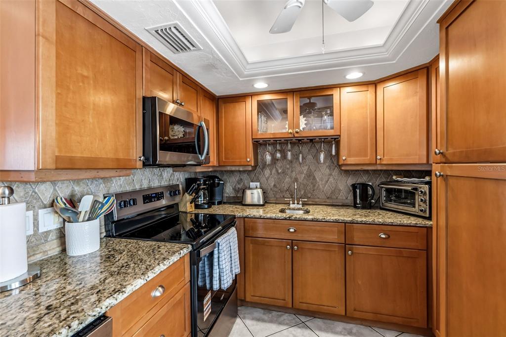 6300 Midnight Pass Road, Unit 708 Sarasota, FL 34242 - Photo 9 of 49 a kitchen with stainless steel appliances granite countertop a sink stove and cabinets