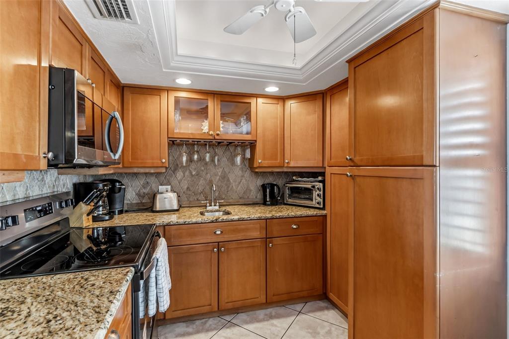 6300 Midnight Pass Road, Unit 708 Sarasota, FL 34242 - Photo 10 of 49 a kitchen with a sink a stove cabinets and a refrigerator