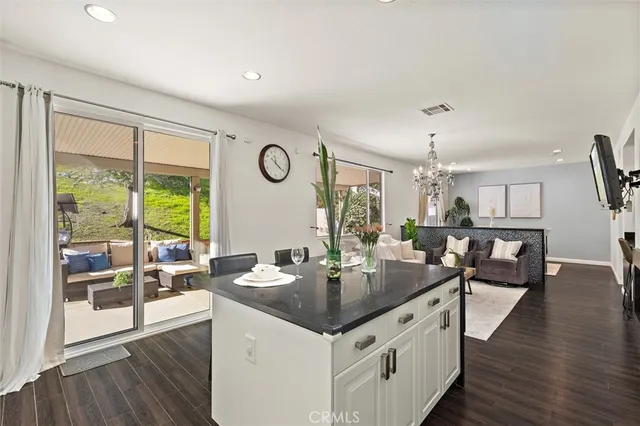 a kitchen with granite countertop a table chairs stove and wooden floor