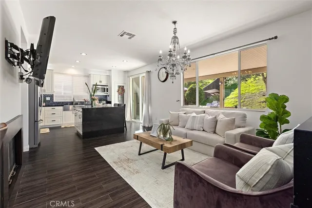 a living room with furniture a fireplace and a chandelier