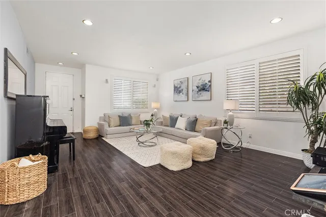 a living room with furniture wooden floor and a potted plant