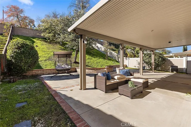 a view of a patio with couches and chairs under an umbrella