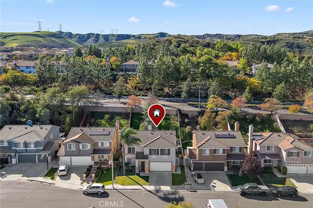 an aerial view of residential houses with outdoor space and parking