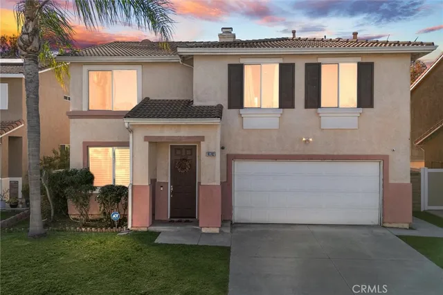 a front view of a house with a garden and plants