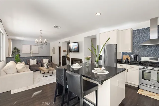 a kitchen with stainless steel appliances kitchen island granite countertop a stove a sink a dining table and chairs