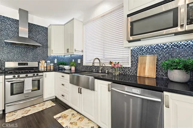 a kitchen with stainless steel appliances a stove a sink and a microwave