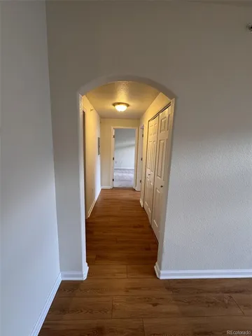 a view of a hallway with wooden floor and staircase