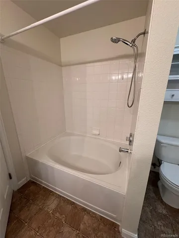 a white bath tub sitting next to a white sink and vanity