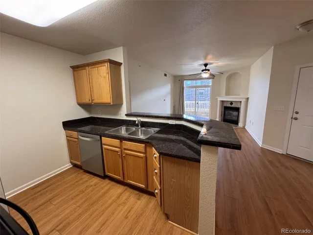 a kitchen with granite countertop a sink cabinets and wooden floor