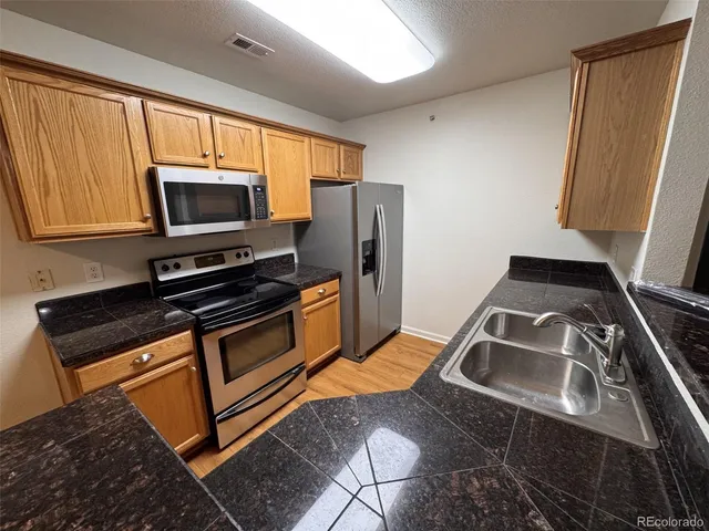 a kitchen with granite countertop a stove and a microwave