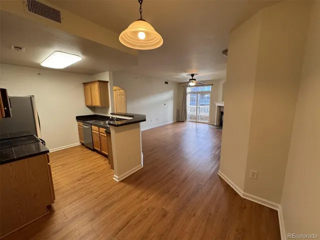 a kitchen with granite countertop a stove and a wooden floors