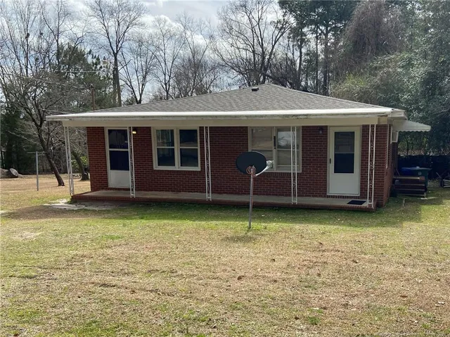 a backyard of a house with barbeque oven and table