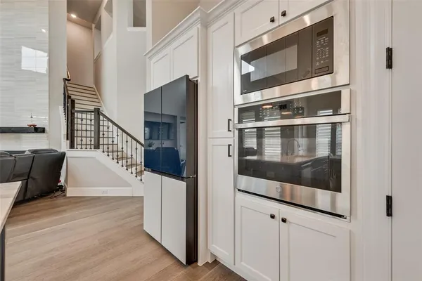 a large kitchen with stainless steel appliances granite countertop a lot of counter space and wooden floors