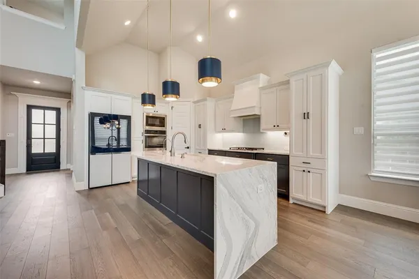 a kitchen with stainless steel appliances granite countertop a stove and a wooden floors