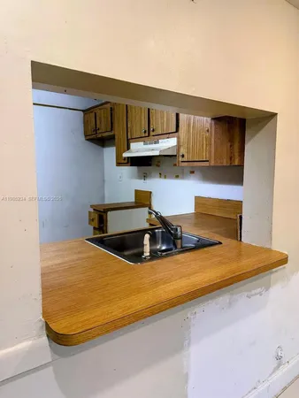 a kitchen with stainless steel appliances granite countertop a sink a stove and white cabinets