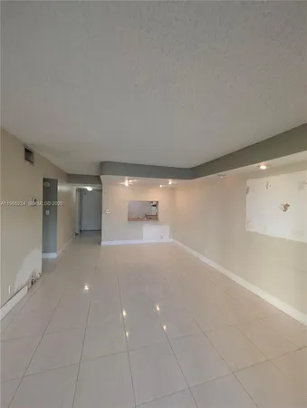a view of a big room with wooden floor and windows