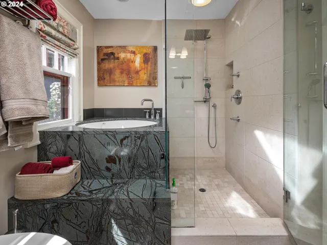 a bathroom with a granite countertop shower a sink and a mirror