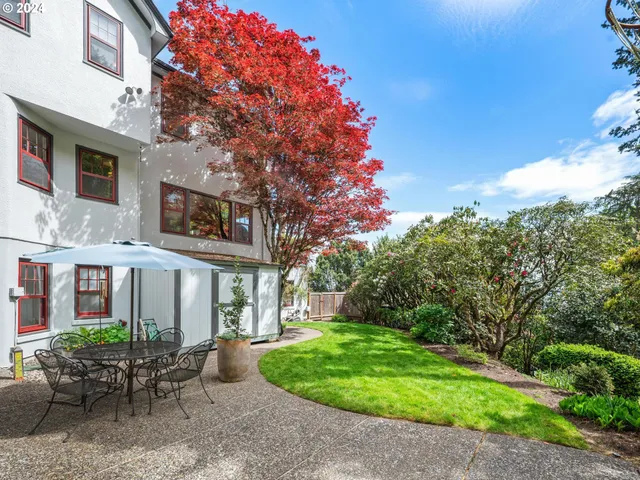 a view of a chair and table in backyard of the house